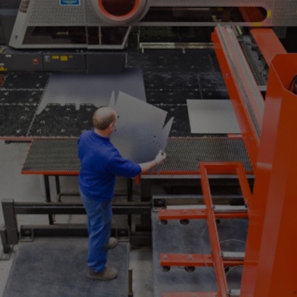 Man standing by sheet metal press in factory